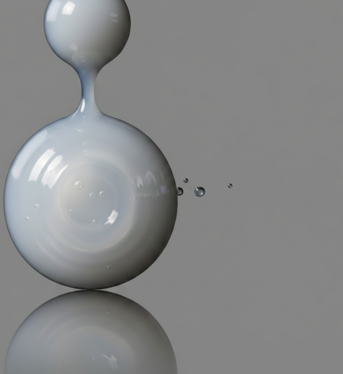 Gray droplet of liquid on a reflective surface with a gray background