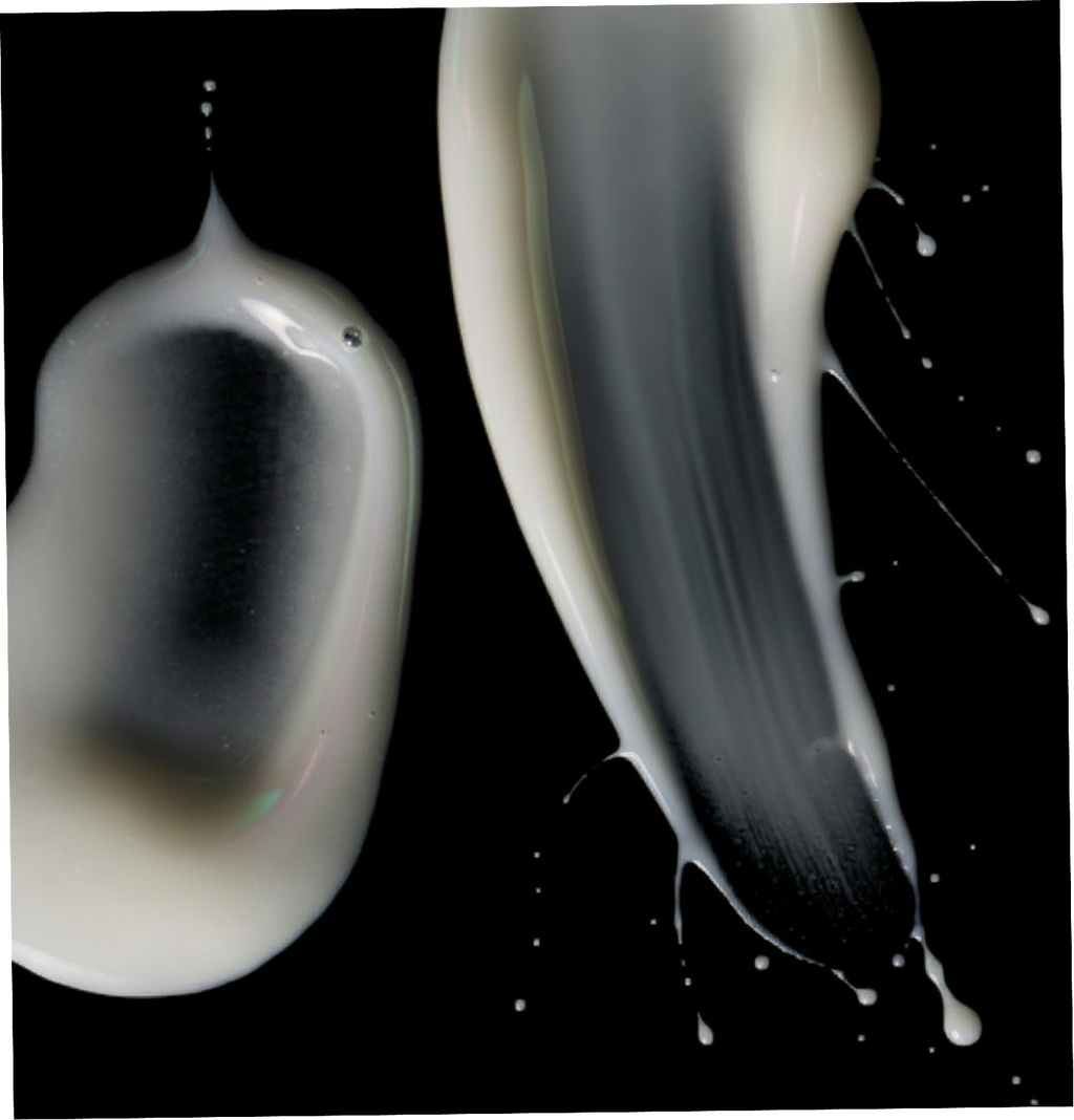 Two droplets of white liquid on a black background