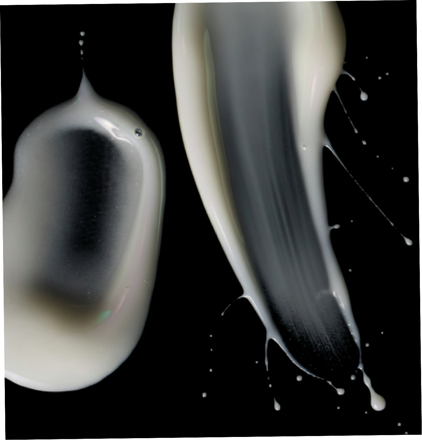 Two droplets of white liquid on a black background