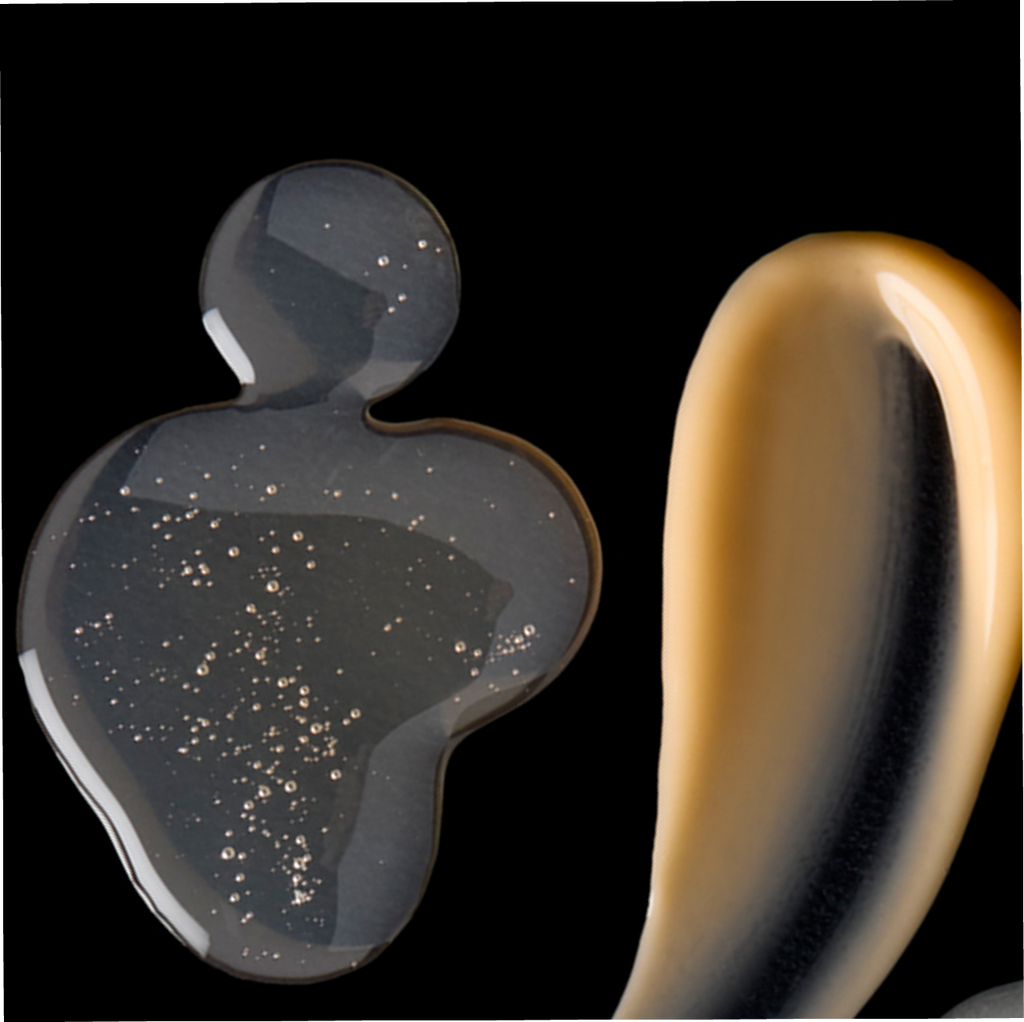 Two metallic objects, one gray and one gold, on a black background