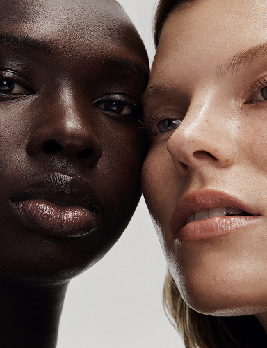 Two people with close faces on a plain background